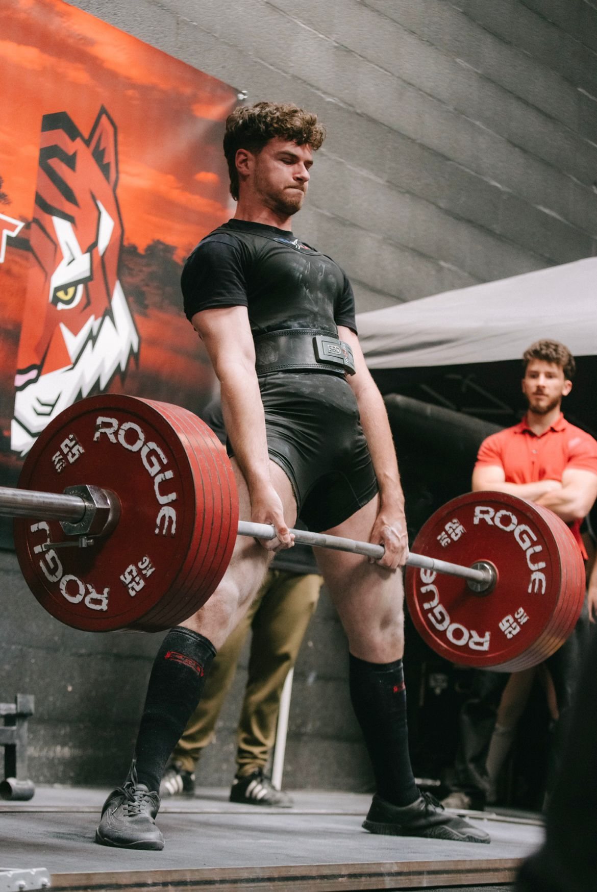 Adrien en plein soulevé de terre, la barre chargée de disques de 25 kg.